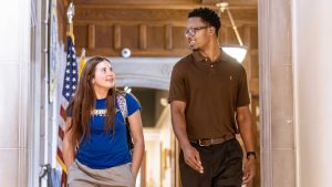 female and male student looking at each other while walking on campus
