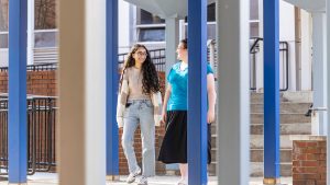 two female students walking on campus talking