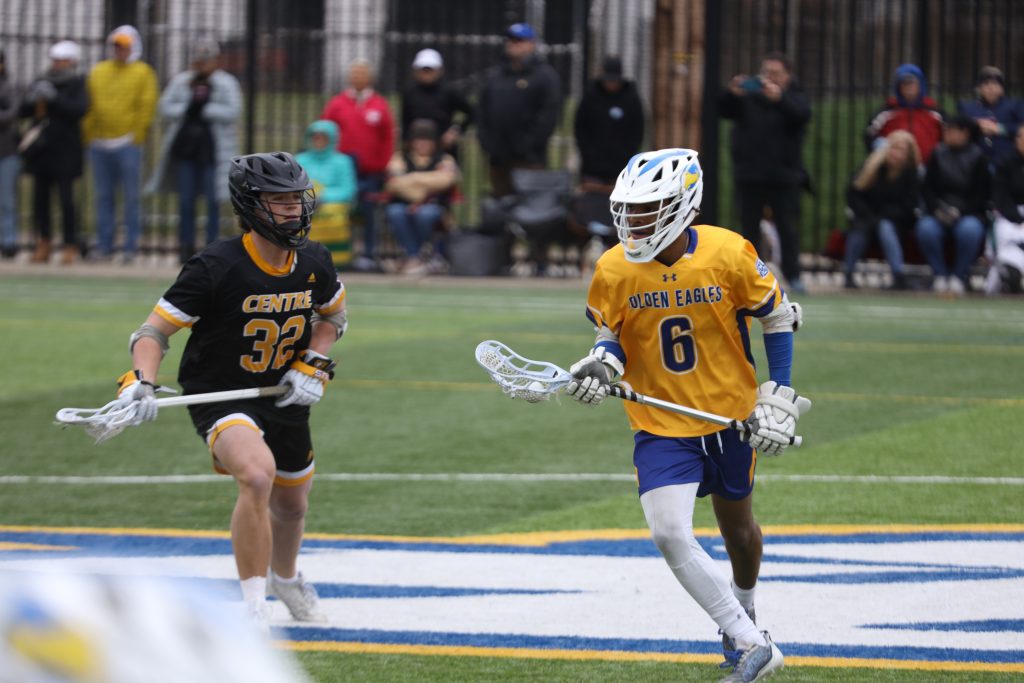 Spalding lacrosse player (right) against player from opposing school