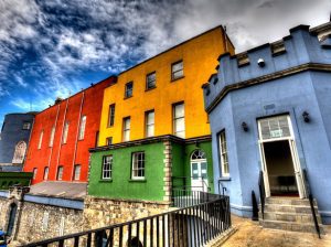 Brightly colored buildings sit atop a rock wall in an international setting