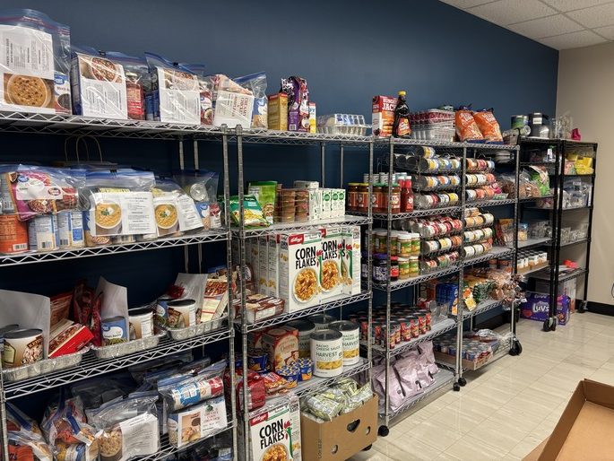 Photo showing several wire shelves with a variety of food neatly organized the in Spalding Pelican Pantry