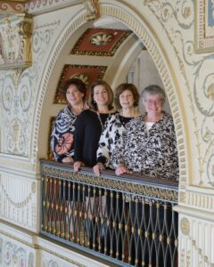 Naslund-Mann faculty members lined up along a balcony railing.