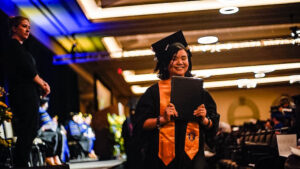 Spalding master's grad walking back with degree