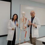 Spalding Nursing professors Missy Hawes and Collan Darnall posing with model skeleton.