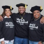 The Colbert family grouped together for a posed picture, wearing matching shirts. From left to right, Danielle Colbert, Brandon Colbert, and Kim Colbert